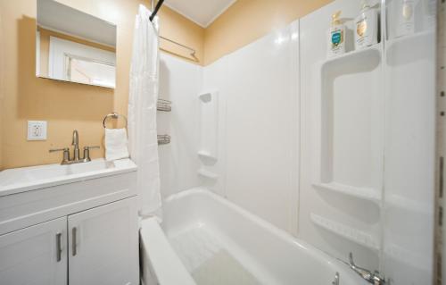 a white bathroom with a sink and a shower at Pura Vida, Live Pure! 2 b, 1 b. in Akron