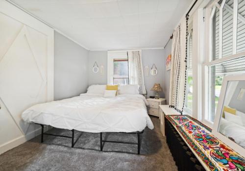 a white bedroom with a bed and a window at Pura Vida, Live Pure! 2 b, 1 b. in Akron