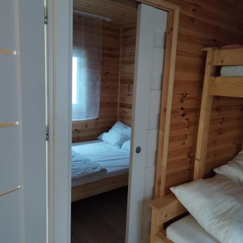 a room with two bunk beds in a wooden room at Domki Letniskowe Meduza in Jarosławiec