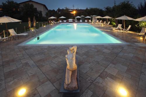 a swimming pool with a statue in front of it at Vip's Motel Luxury Accommodation & Spa in Lonato del Garda