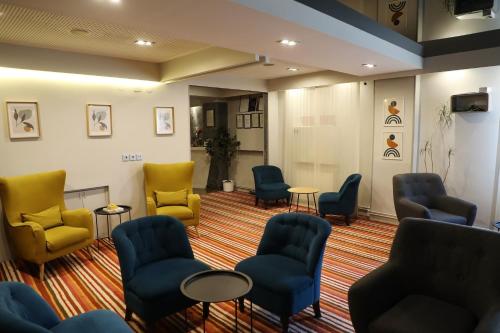 uma sala de espera com cadeiras e mesas azuis e amarelas em Hotel Sokak em Sarajevo
