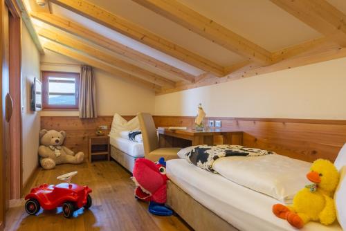 a bedroom with two beds and stuffed animals in it at Hotel Emmy - five elements in Fiè