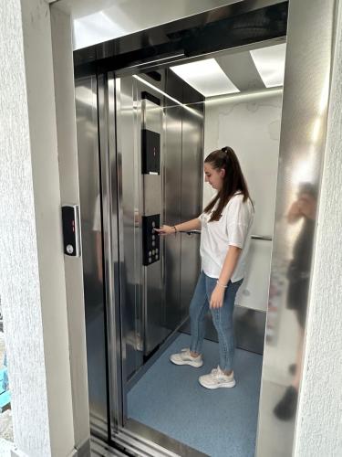 a woman standing in front of a metal elevator at Hotel Mira Mare in Ksamil