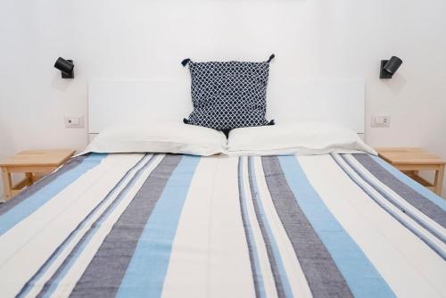 レトイアンニにあるcasa Taorminaの青と白のストライプのベッドカバーが備わるベッド1台