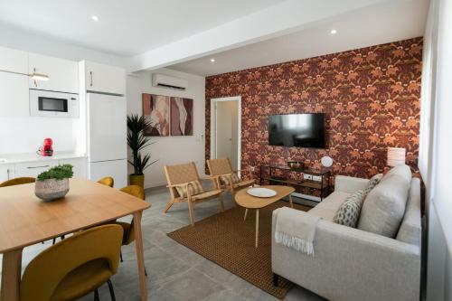 a living room with a couch and a table at Lujoso apartamento con piscina compartida 3 in Seville