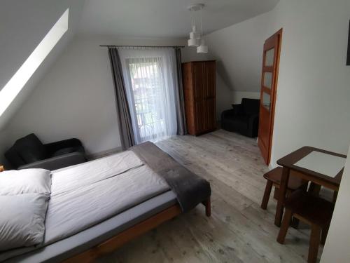 um quarto com uma cama e uma secretária num quarto em Noclegi na Wygonie em Sromowce Niżne