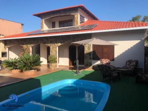 uma villa com piscina em frente a uma casa em Casa Familiar com Piscina e Churrasqueira em Foz do Iguaçu