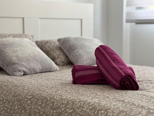 a purple towel laying on a bed with pillows at Chalet en Hazas de Cesto in Hazas de Cesto