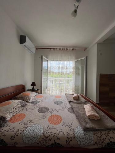 a bedroom with a large bed with a large window at Apartment Kovach Kuti in Herceg-Novi