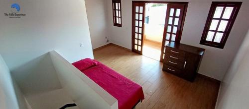 um quarto com uma cama, uma cómoda e duas janelas em Casa Familiar com Piscina e Churrasqueira em Foz do Iguaçu