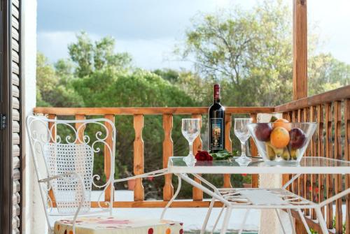 un tavolo con una bottiglia di vino e bicchieri sul portico di Romanza Villas a Sitia