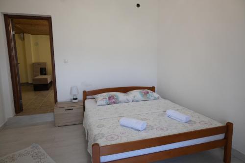a bedroom with a bed with two pillows on it at Apartman Delać in Tivat