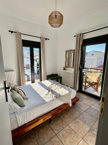 a bedroom with a bed and a large window at Rania Residence in Skopelos Town
