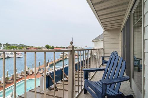 two blue chairs sitting on a balcony overlooking the water at St Michaels Harbour Inn, Marina and Spa in Saint Michaels