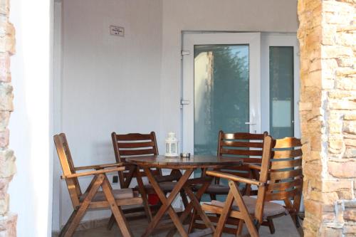 a wooden table and chairs on a porch at Къща за гости Света Марина in Krapets