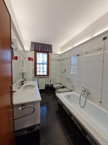 a bathroom with a tub and two sinks and a bath tub at Appartamento incantevole a Massarosa tra Viareggio e Lucca in Massarosa