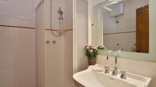 a white bathroom with a sink and a shower at Casa Isabella in Gaiole in Chianti