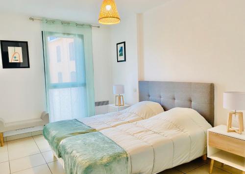 un grand lit dans une chambre avec une fenêtre dans l'établissement APPARTEMENT 2 CHAMBRES AVEC BALCON ET PARKING, à Perpignan