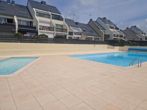 a swimming pool in front of some apartment buildings at GUIDEL-PLAGES Studio Lumineux Balcon Vue Mer & Piscine in Guidel