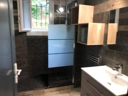 ein Badezimmer mit Waschbecken, Spiegel und Fenster in der Unterkunft maison individuelle in Laveissière