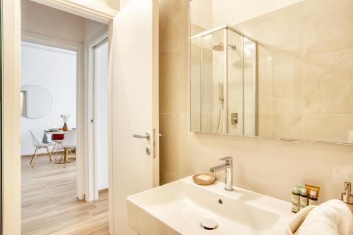 ein Bad mit einem Waschbecken und einem Spiegel in der Unterkunft Relais Milano Suite 1 in Mailand