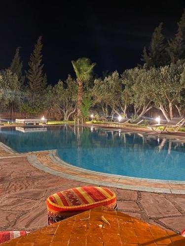a swimming pool at night with a surfboard on the ground at Riad Sidi Hicham in Marrakech