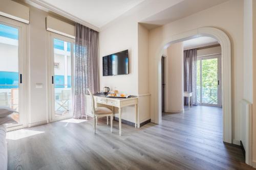 uma sala de estar com uma mesa e vista para o oceano em Parco dei Principi Boutique Hotel em Rimini