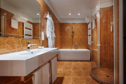 a bathroom with a sink and a tub and a shower at Parco dei Principi Boutique Hotel in Rimini