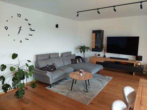 a living room with a couch and a clock on the wall at Luxury Apartment Ljubljana in Ljubljana