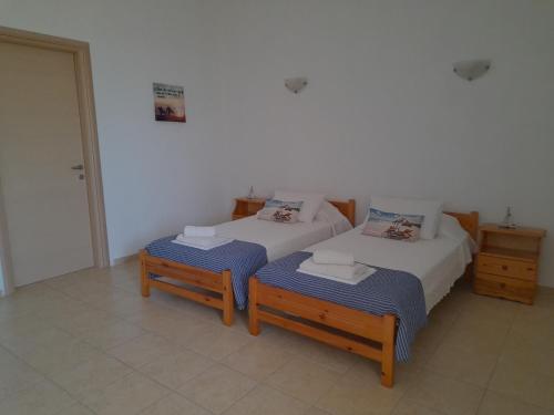 a bedroom with two twin beds and two tables at Garden View Appartment (Thanasis) in Kalavárda