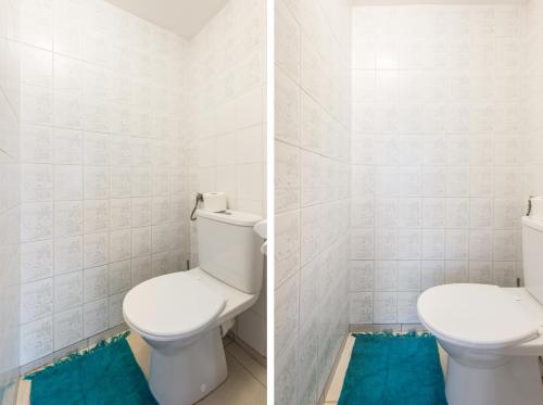 a bathroom with a white toilet and a blue rug at SuperApart Inflancka 19 ROOMS in Warsaw