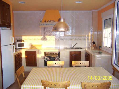 eine Küche mit einem Tisch, einer Spüle und einem Kühlschrank in der Unterkunft AGUAVIVA in Argüero