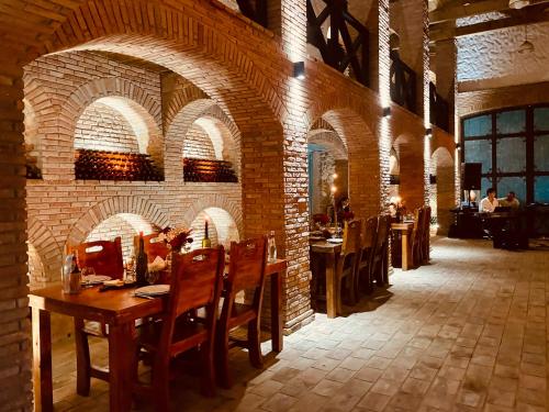 a restaurant with brick walls and a table and chairs at Javakhishvilebis Marani in Akhalsopʼeli