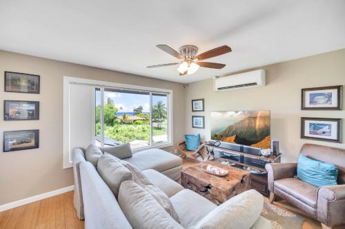 a living room with a couch and a ceiling fan at Hale Kahana'lu condo in Koloa