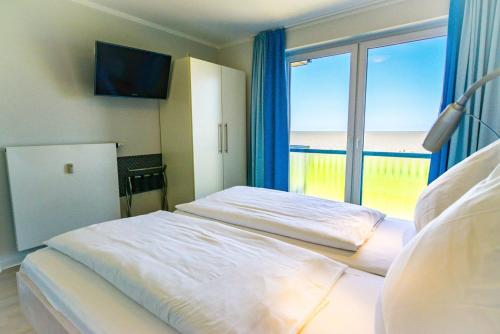 a bedroom with a bed with a view of the ocean at Beach Lodge BL04 in Cuxhaven
