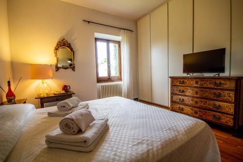 Un dormitorio con una cama blanca con toallas. en Il Vago Soggiorno en Barberino di Mugello