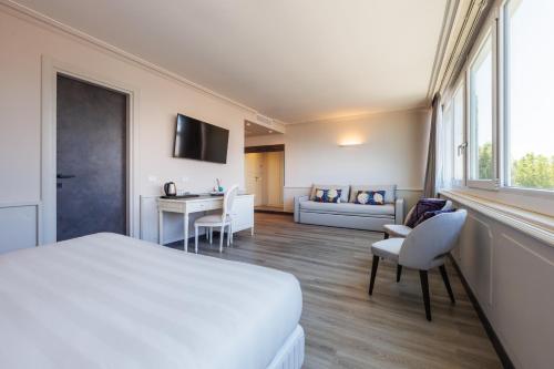 a hotel room with a bed and a couch at Parco dei Principi Boutique Hotel in Rimini