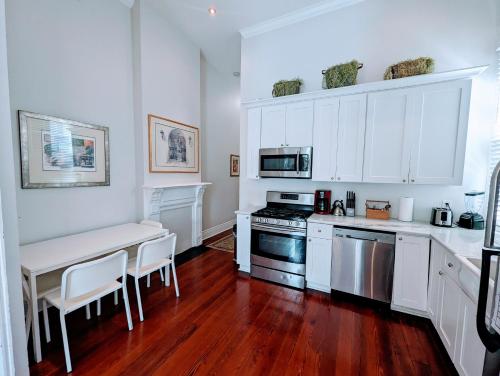 a kitchen with white cabinets and a table and a stove at Royal Residence in New Orleans