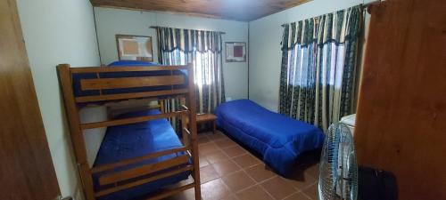 a room with two bunk beds and a ladder at CABAÑA AKAPANA in Huerta Grande