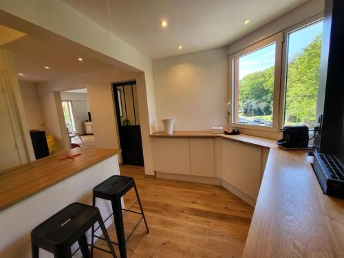 an office with a desk with two stools and a laptop at Superbe T3 lumineux sur parc arboré avec piscine in Anglet