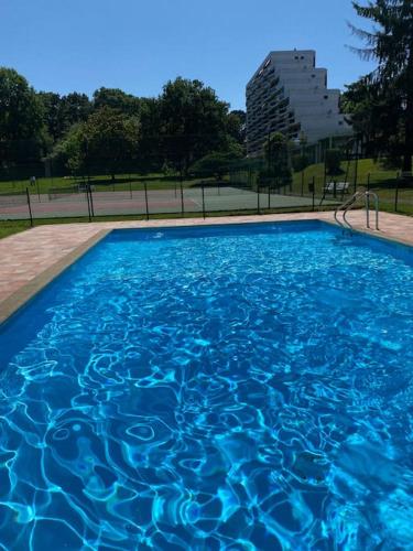 - une piscine d'eau bleue dans un parc dans l'établissement Superbe T3 lumineux sur parc arboré avec piscine, à Anglet