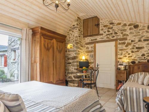 a bedroom with a bed and a stone wall at Confort et Tranquillité à Blain : Chambre Climatisée, Salle d'Eau Privative, Wifi et Vélos à Disposition - FR-1-306-1253 in Blain