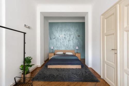 1 dormitorio con cama y pared azul en Spacious apartment with balcony at Wenceslas Sq, en Praga