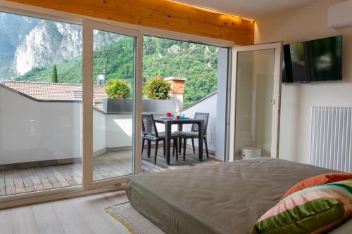 a bedroom with a bed and a balcony with a table at Charming Loft - Private Hot Tub & Free Parking in Riva del Garda