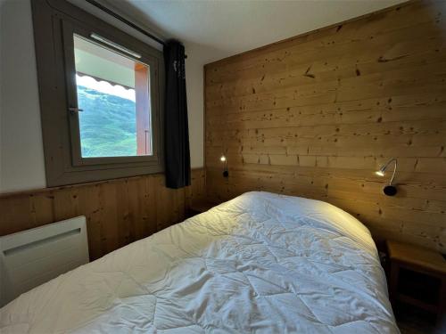 une chambre avec un lit et une fenêtre dans l'établissement Beau 2 pièces cabine au pied des pistes avec balcon, animaux bienvenus - FR-1-452-153, aux Menuires