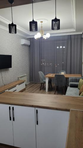 a living room with a table and a dining room at Sea View House in Sumqayyt