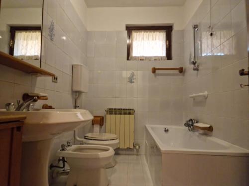 a bathroom with a toilet and a tub and a sink at Omary in Colà di Lazise