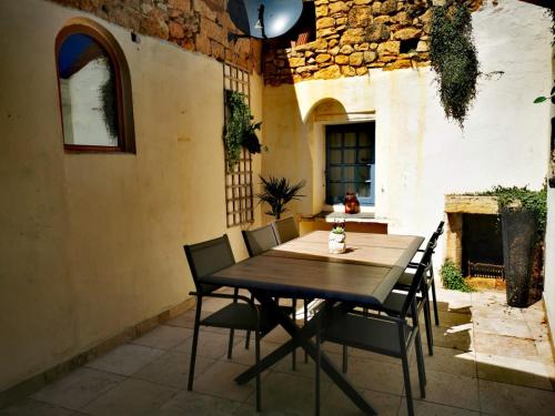 einen Holztisch und Stühle auf einer Terrasse in der Unterkunft Maison de la Combe in Domme