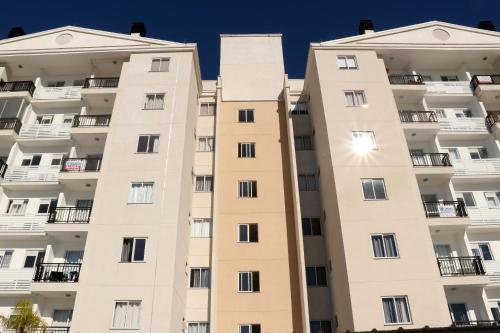an apartment building in front of a blue sky at Curta Praia do Quilombo - Palladium in Penha