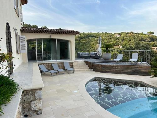 un patio trasero con piscina y una casa en Maison familiale, avec vue imprenable, en Montauroux